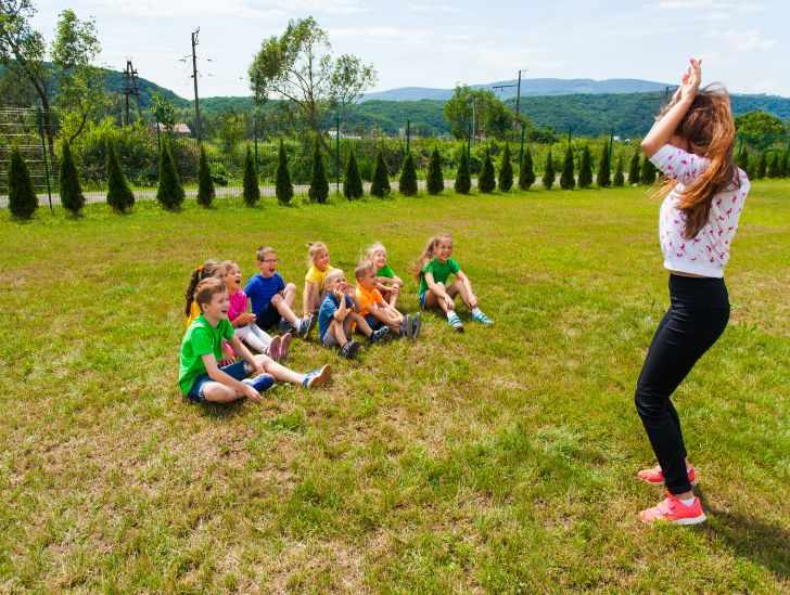 Kids playing charades outdoors.
